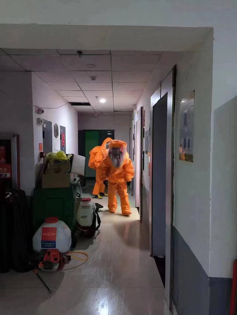 社區出現了陽性病例後，重裝防護的消殺人員開始對居民樓進行消殺。（知情人提供）