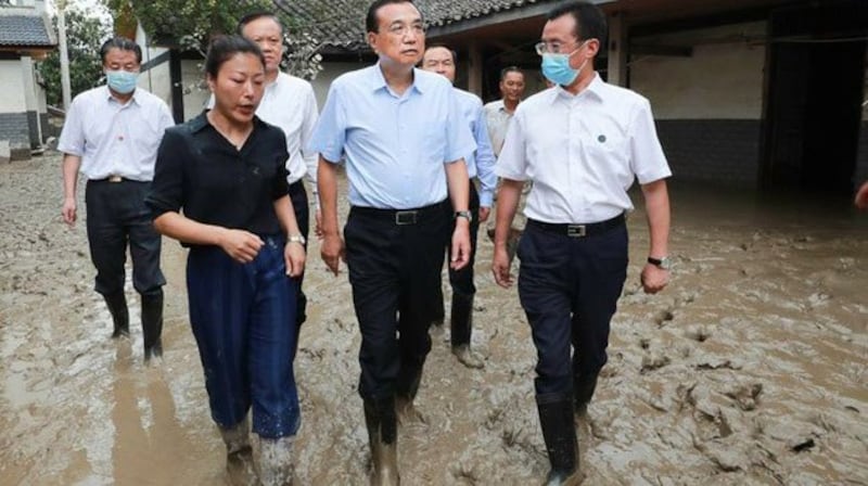 中国总理李克强本周四赴重庆市视察灾情期间，涉水查看农作物及慰问灾民，并承诺“政府一定会帮助度过难关。（图/中国政府网）