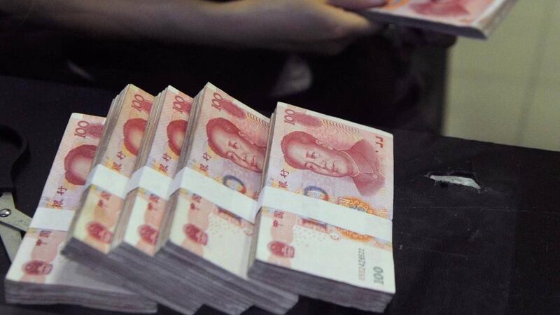 တရုတ်နိုင်ငံ ကုန်သည်ဘဏ်တစ်ခုတွင် တရုတ်ယွမ်ငွေများ ရေတွက်နေသူတစ်ဦးကို တွေ့ရစဥ်။ (Photo: Reuters)