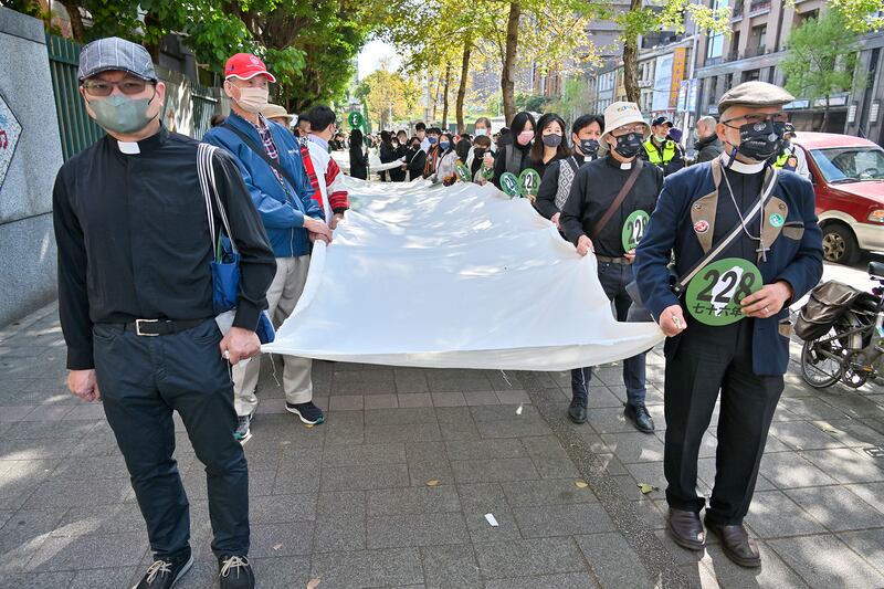 遊行隊伍抬著多幅白布悼念二二八事件死難者。（鍾廣政攝）