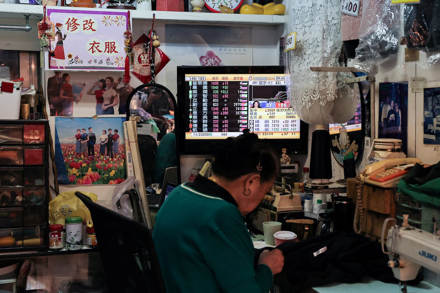 A person sits near a TV showing a live broadcast of the US election on the morning news at a store in Taipei, Taiwan Nov. 6, 2024.