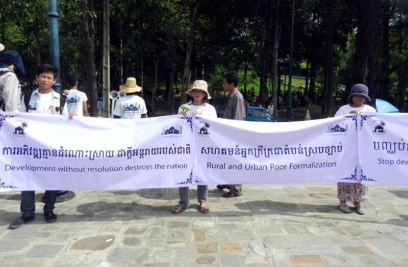 ក្រុម​ពលរដ្ឋ​មាន​ជម្លោះ​ដីធ្លី​លើក​បដា​តវ៉ា​សុំ​ឲ្យ​រដ្ឋាភិបាល​ដោះស្រាយ​បញ្ហា​ដីធ្លី នា​រមណីយដ្ឋាន​វត្ត​ភ្នំ រាជធានី​ភ្នំពេញ នៅ​ថ្ងៃ​ទី១០ ខែ​តុលា ឆ្នាំ​២០១៣។