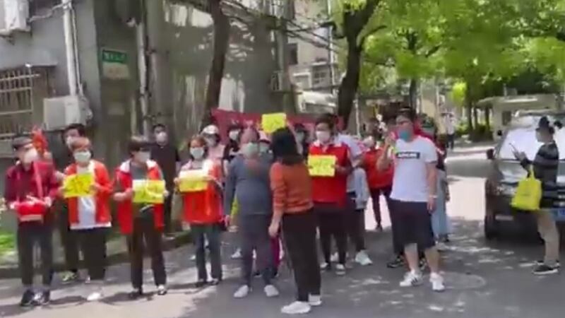 上海一小區的十多人慶祝解封,有居民上前阻止,指當前並未解封。(視頻截圖)