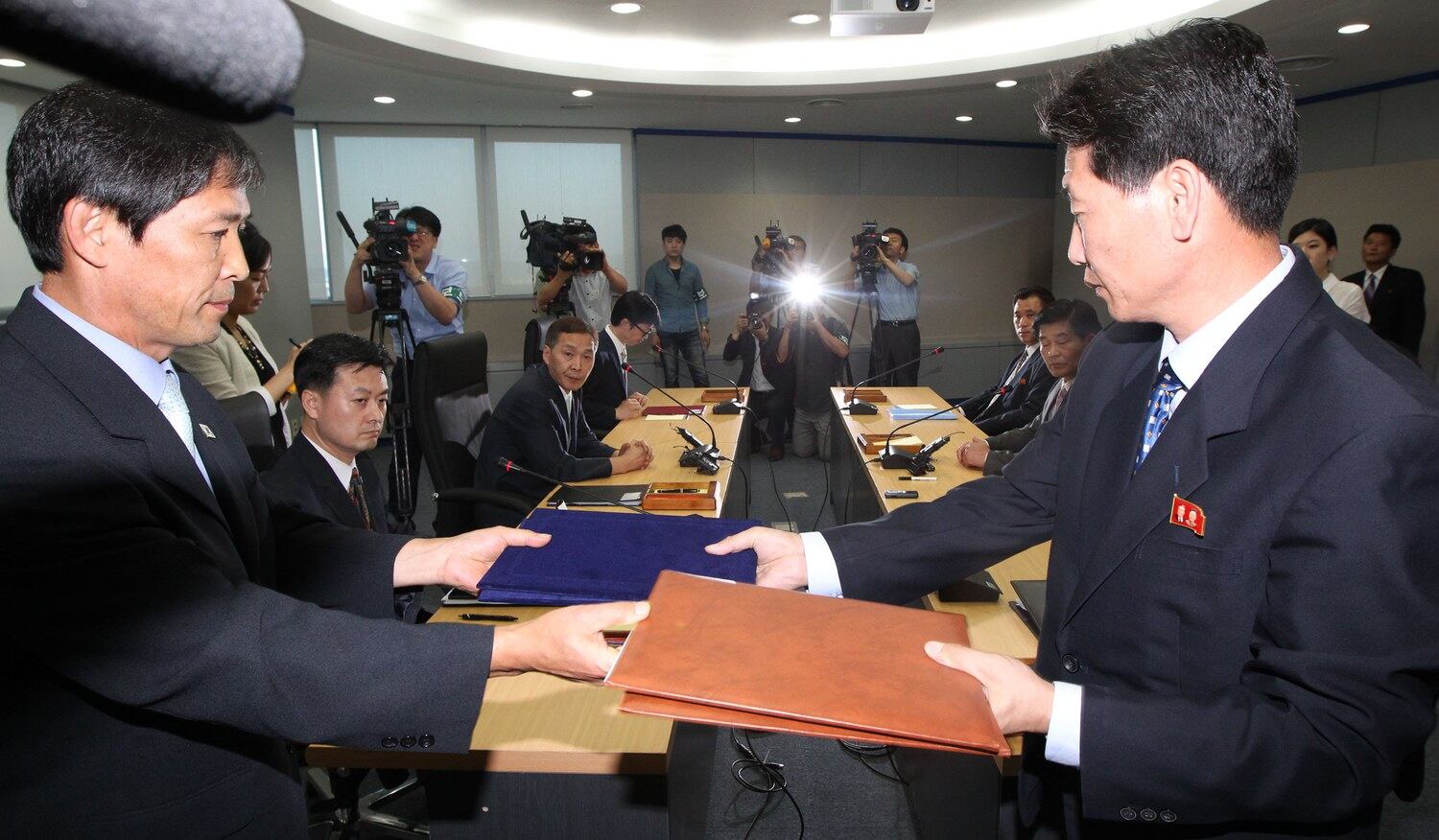 제7차 개성공단 남북당국실무회담이 14일 개성공단 종합지원센터 회의실에서 열려 극적인 타결을 한 가운데 양측 대표단이 합의서를 교환하고 있다.