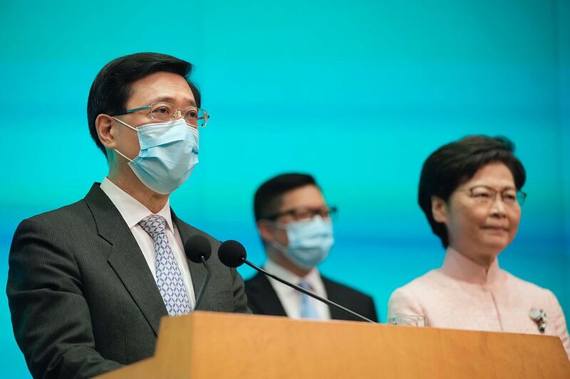 2021 年 6 月 25 日，香港行政长官林郑月娥、保安局局长邓志强和香港政务司长李家超（左）在新闻发布会上。 （美联社）