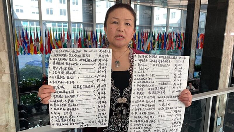 萨吾提拜没有带着奖牌受访,而是手拿两张海报纸、上头写满仍关押在再教育营里或下落不明族人的名字,要为他们发声。(自由亚洲电台记者郑崇生华盛顿摄)
