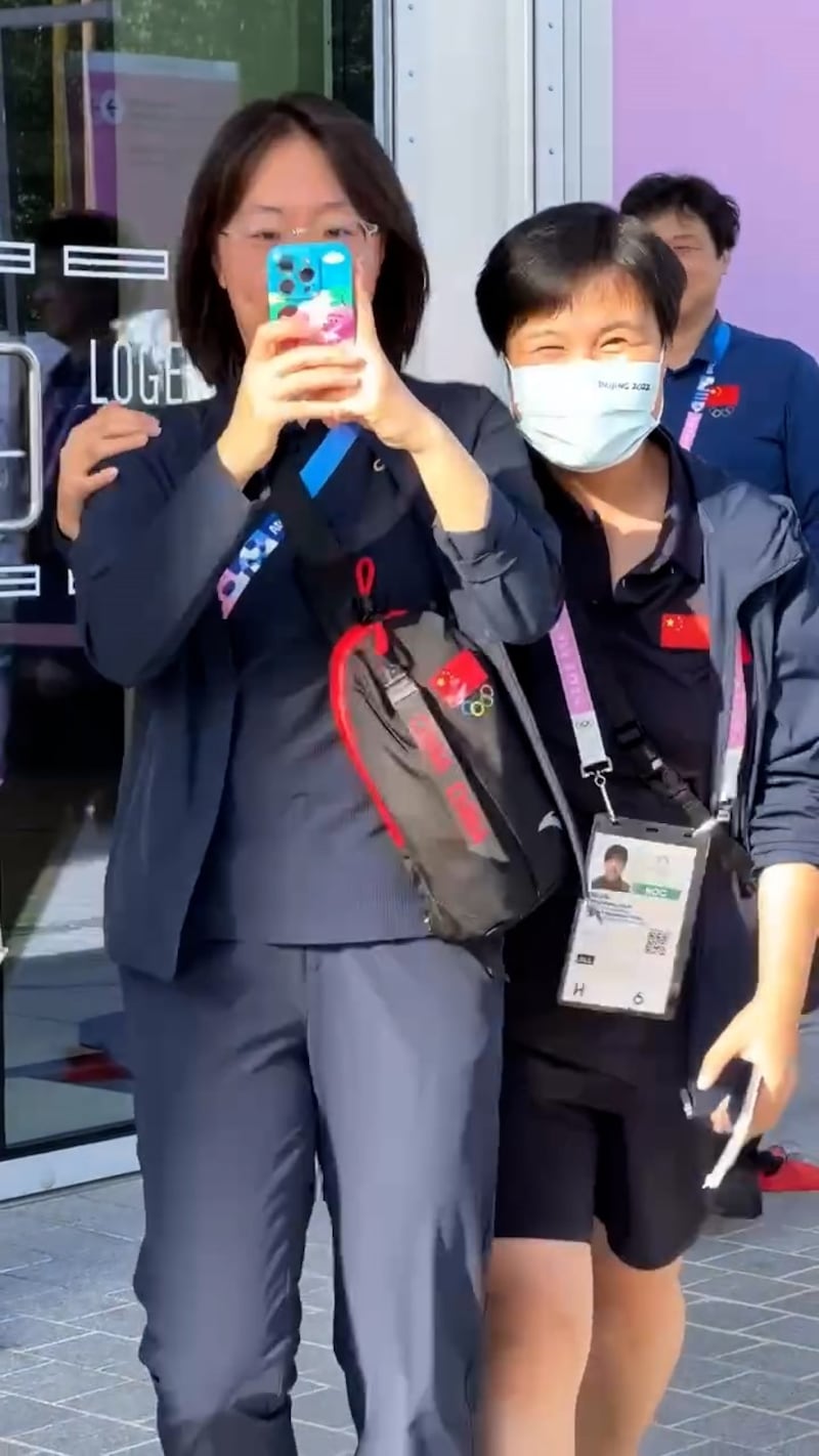 圖中的中國女子，被指在場內向保安舉報，應沒收哪些旗幟或紙牌。（Thread截圖）