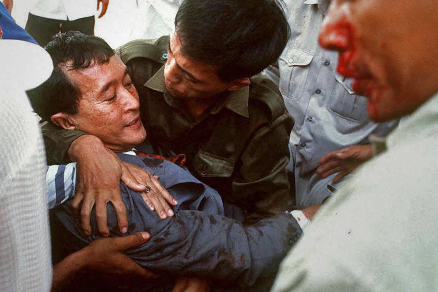 Sam Rainsy is carried to safety after a grenade attack on a group of demonstrators outside the National Assembly building in Phnom Penh, March 30, 1997.