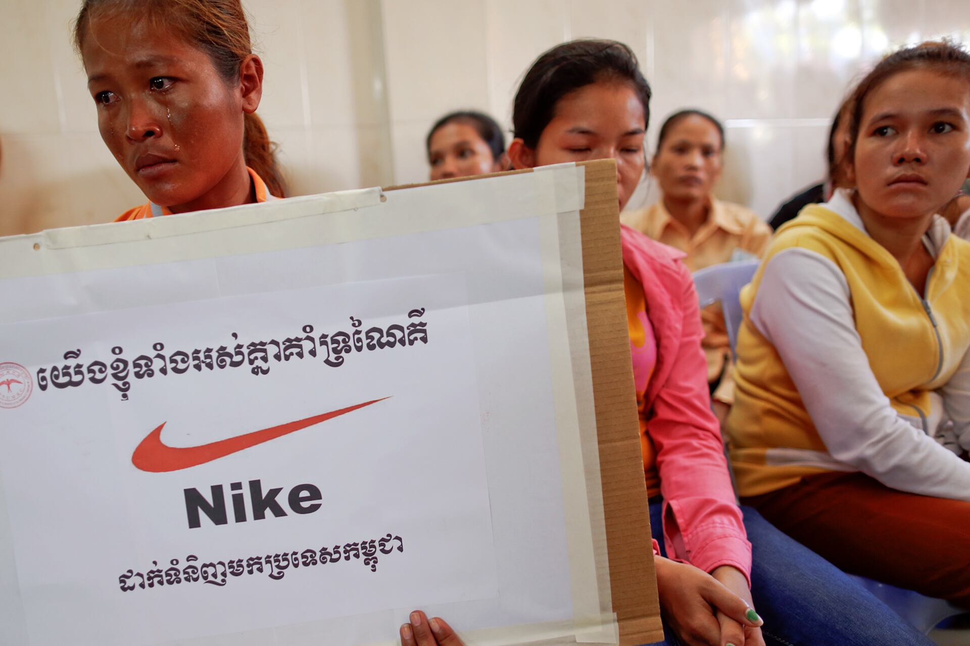 Som Cheantha, an eight-month-pregnant garment worker cries as she holds a sign during a gathering of workers at their union headquarters in Phnom Penh June 27, 2013.