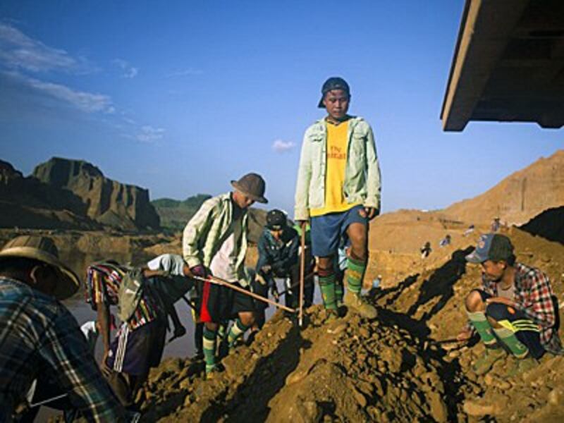 Scavengers dig for raw jade stones in piles of waste rubble next to a jade mine in Hpakant, northeastern Myanmar's Kachin state, Oct. 4, 2015.
