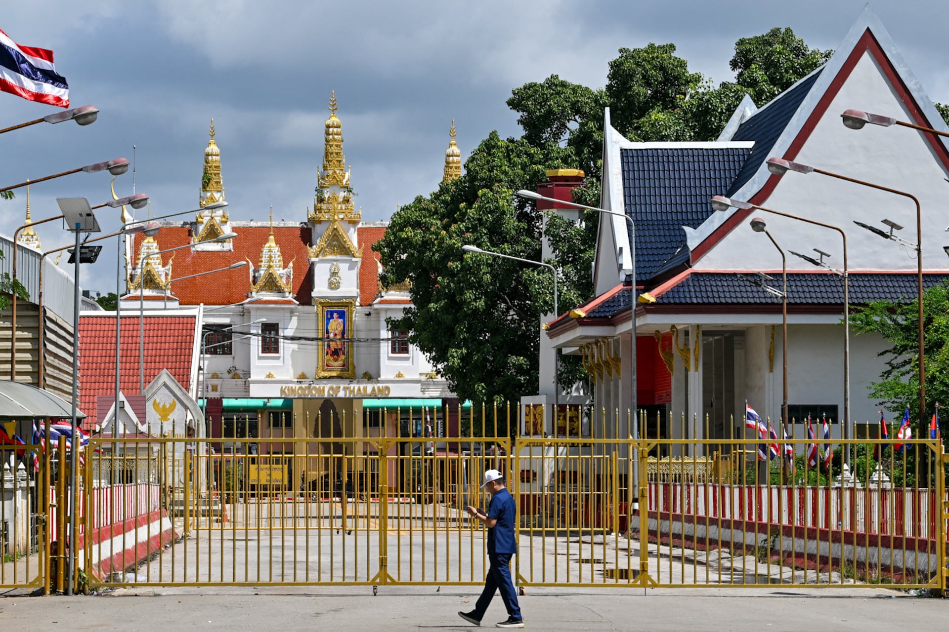 A man walks near the closed gate at Poipet International border checkpoint between Cambodia and Thailand, at Poipet town in Banteay Meanchey province on June 25, 2025.