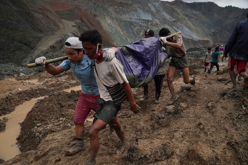 Rescue workers carry a body shrouded in plastic sheeting, in Hpakant, Kachin state, Myanmar, July 2, 2020, after a landslide killed more than 160 people. Credit: Zaw Moe Htet/AP