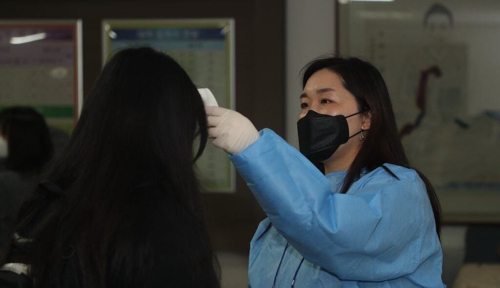 2022학년도 대학수학능력시험이 치러지는 전북 전주시 완산구 근영여자고등학교에서 수험생들이 체온을 체크하고 있다.