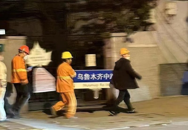 2022年,當局派人拆除上海烏魯木齊中路的路牌,影像成了「白紙運動」的圖騰。(「夏巢川 Rei Xia」X帳號圖片)