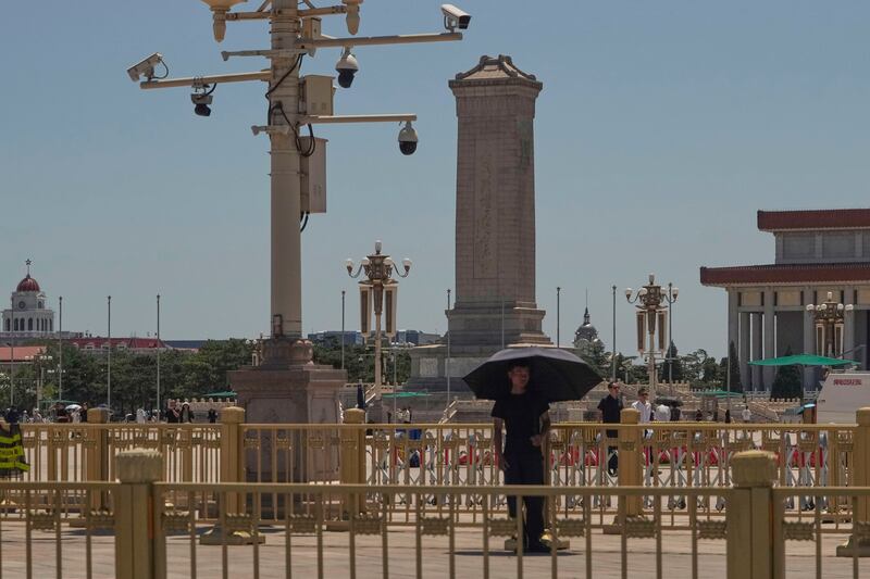 A plainclothes security person stands on duty near security cameras overlooking Tiananmen Square on the anniversary of China's bloody 1989 crackdown on pro-democracy protests in Beijing, June 4, 2025.