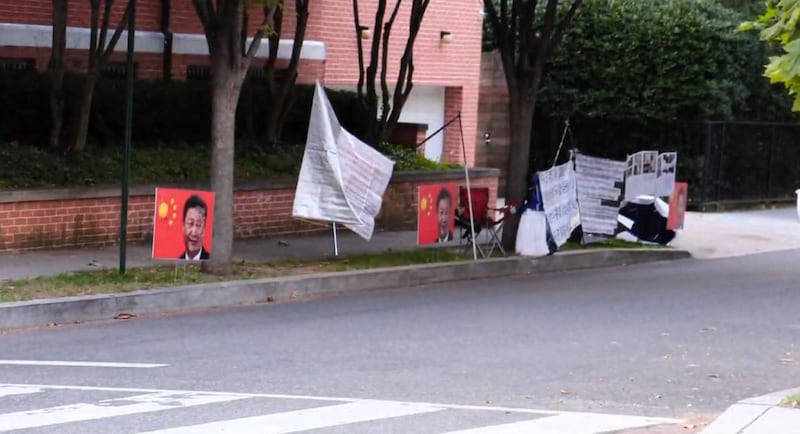 访民在中国驻美大使官邸前放置的图片与抗议标语(视频截图/记者Jim Jo)
