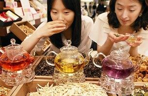 AK플라자 구로본점 한방약초차 매장에서 모델들이 약초차 향을 맡아보는 모습.