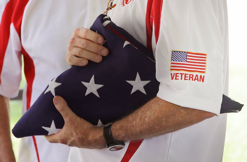 Former Marine Sgt. Kevin Maloney of Hollywood, Florida, holds a U.S. flag during the unveiling ceremony of a plaque dedicated to his fallen comrades who were the last U.S. servicemen killed in the Vietnam War, at the U.S. Consulate in Ho Chi Minh City, Vietnam, April 30, 2015.