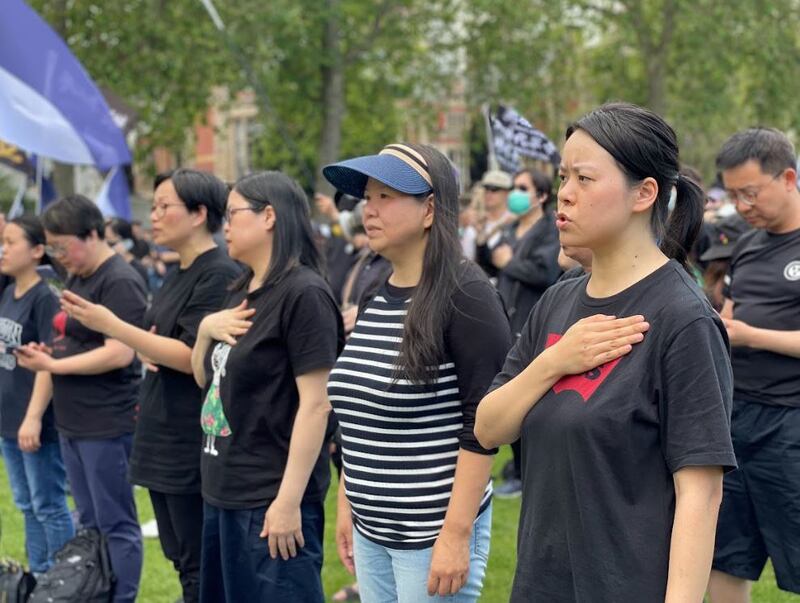近千名港人酷热下在英国国会大楼前“如水再聚”,无惧港府恐吓,高唱《愿荣光归香港》。不少参加者颂唱时手放胸前,神情凝重。(吕熙摄)