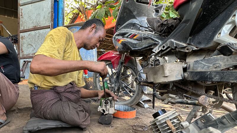 မန္တလေးတိုင်း၊ တံတားဦးမြို့က မသန်စွမ်းတစ်ယောက်ဖြစ်သူ ကိုမြင့်စိုးအောင် ဆိုင်ကယ်ပြုပြင်နေသည်ကို ၂၀၂၃ ခုနှစ်၊ နိုဝင်ဘာလ ၁၀ ရက်နေ့က တွေ့ရစဉ်။ (Photo: RFA)