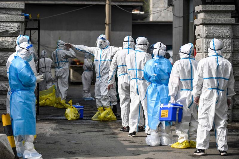 资料图：提交核酸检测样本的吉林医务工作者正在等待消毒（Xinhua via AP）