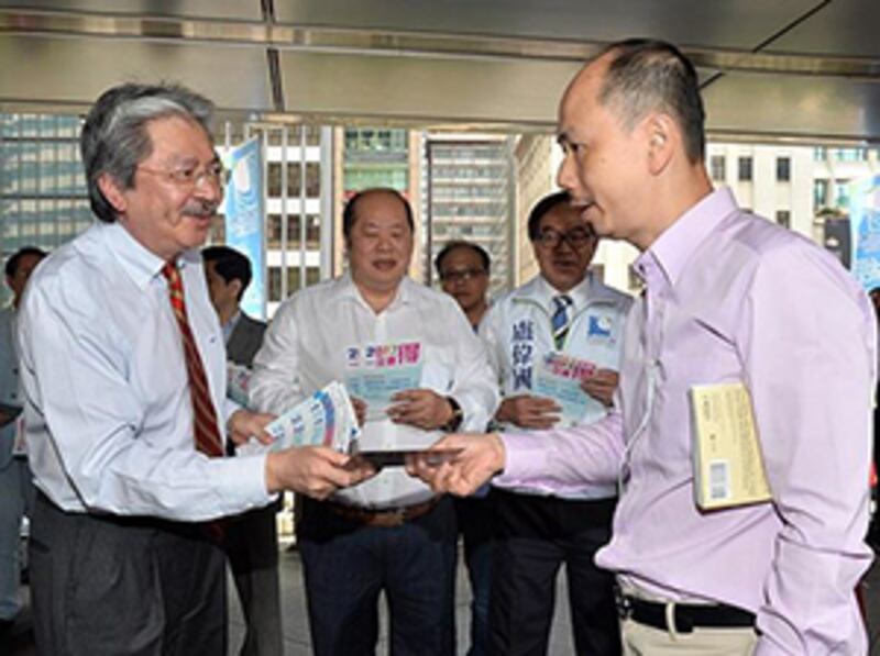 2015年4月30日，財政司長曾俊華到中環向市民派發傳單，他指政治和經濟關係密切，如果政制原地踏步，經濟亦可能達到樽頸。(香港政府新聞網截圖)