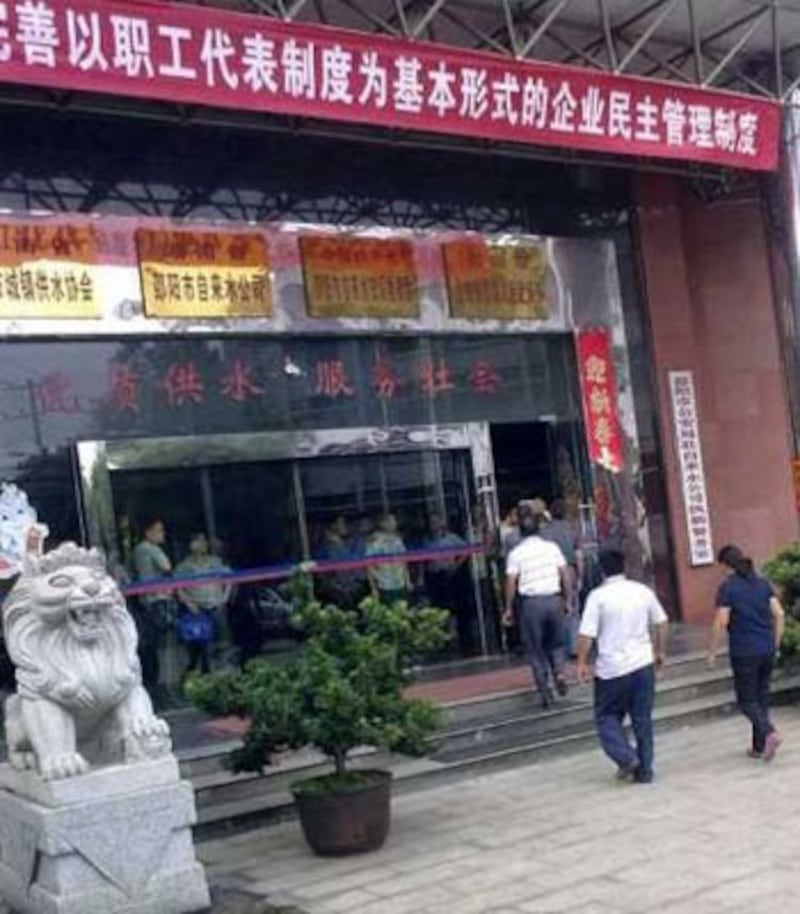 湖南邵陽自來水公司周一(8月27日)發生襲擊事件,起火的會議室外牆燻黑,大批警察在場戒備。(網民提供)