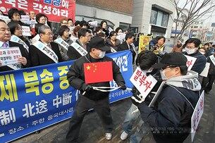 2012년 2월 주한 중국대사관 맞은편 길에서 열린 탈북자 강제 북송 중단 촉구 대국민 기자회견에서 한국자유총연맹 회원들이 중국 공안에 의해 탈북자들이 끌려가는 모습을 형상화한 탈북자 북송 중단 촉구 퍼포먼스를 펼치고 있다. 