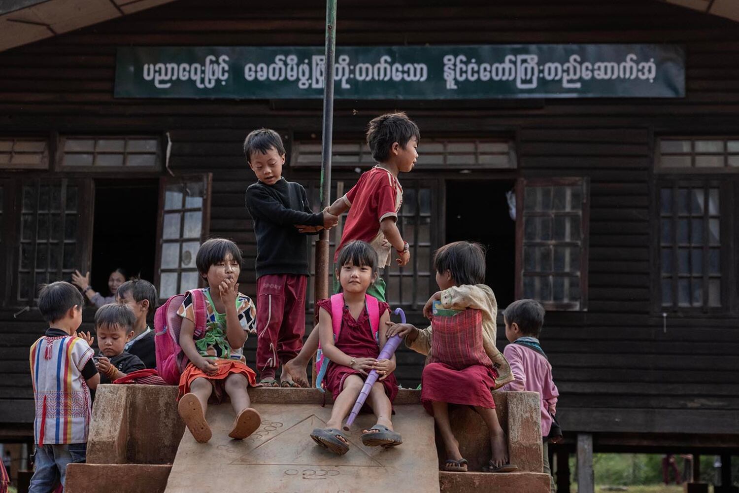 Schoolchildren play near a building damaged by a March 2024 junta airstrike in Lwe Yin town, southern Shan state Myanmar, Oct. 28, 2024.