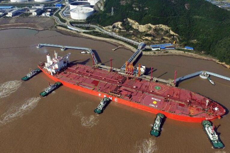 Tugboats dock an oil tanker on a crude oil quay at a port in Zhoushan, eastern China's Zhejiang province, Nov. 11, 2016.
