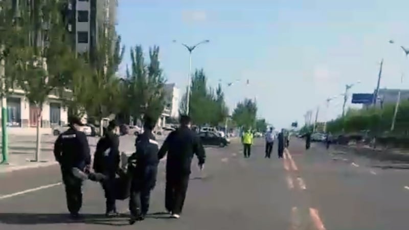 科尔沁左翼后旗一学生家长被4名公安抬向警车。（志愿者提供/记者乔龙）