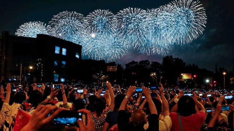 中国国庆70周年上的学生们在拍摄烟火。(美联社)