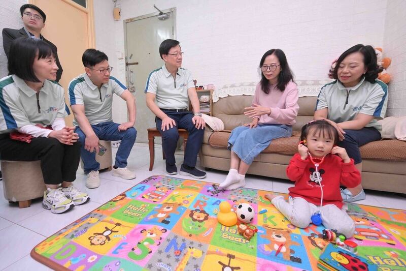 李家超與社區保姆交談，了解她和受照顧幼兒的日常生活情況。（政府新聞網相片）