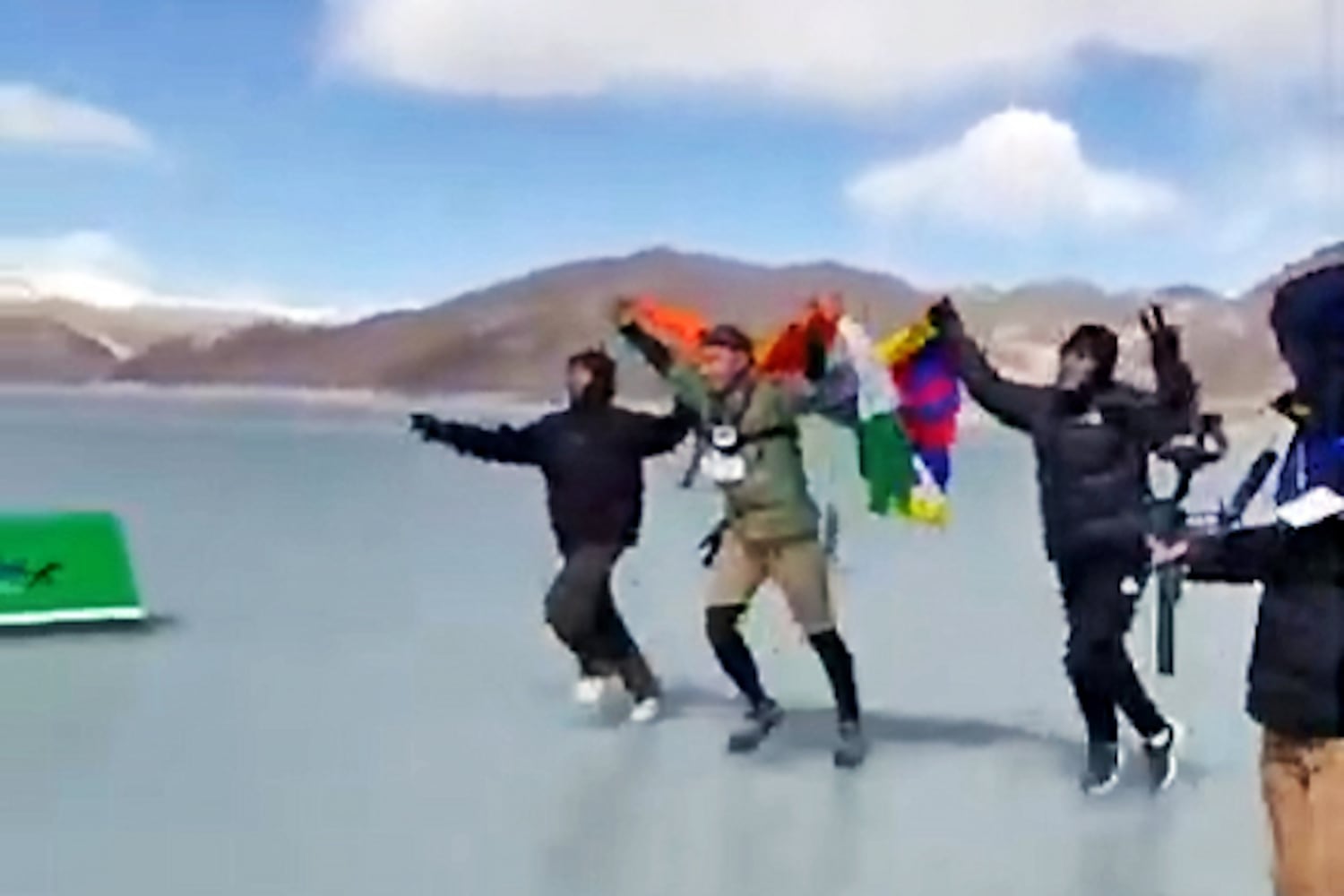 Tibetan runner Lobsang Tharchin, center, approaches the finish line of the Pangong Frozen Lake Marathon, on the India - TIbet border, Feb. 25, 2025. Image from video.