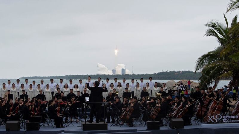 2021年4月29日,西安交响乐团露天演奏,背后的火箭升空。(路透社)