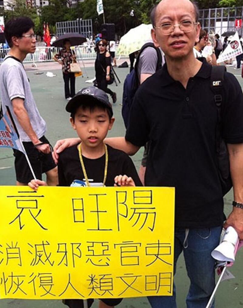 2012年7月1日，有市民帶著寫有悼念李旺陽的橫額參與七、一遊行，要求中央公正徹查他的死因。（粵語部林靜攝）