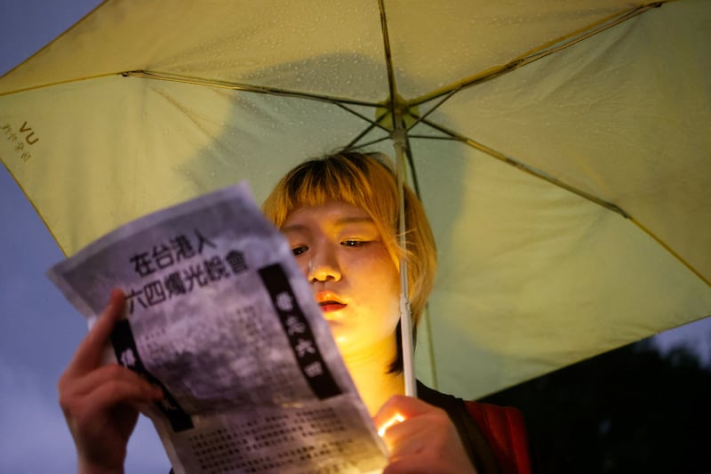 A woman holds a poster for a candlelight event to commemorate the 36th anniversary of the crackdown on pro-democracy demonstrators in Tiananmen Square on June 4, 1989, in Taipei, Taiwan June 4, 2025.