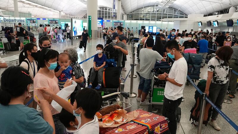 2021 年 6 月 30 日，人们在香港机场排队等候办理登机手续移居英国。（美联社）
