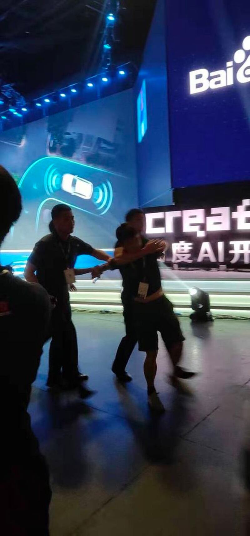 向李彦宏淋水的男子被保安带离会场。（Public Domain）