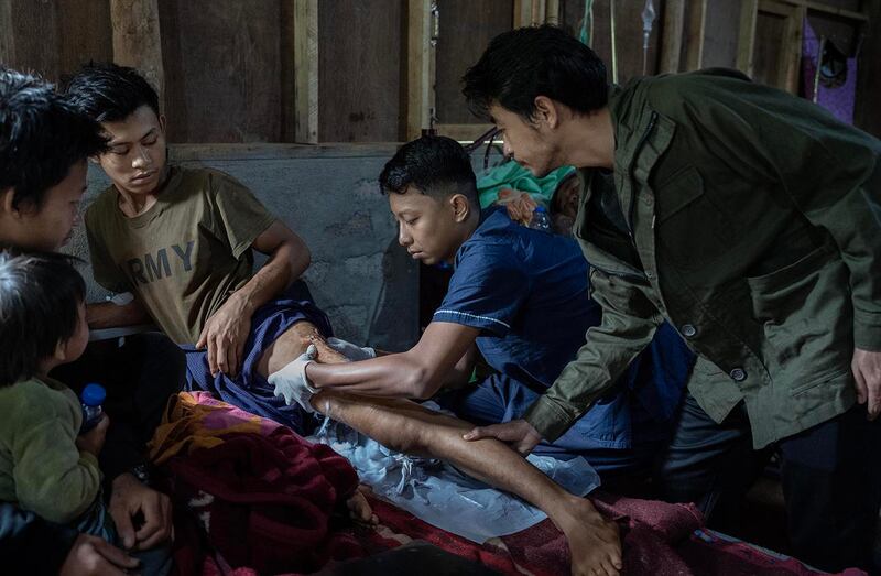 Surgeon Aung Ko Myint, right, and Dr. Yori treat gunshot wounds suffered by Saw Thein Win when he was shot by Myanmar junta security forces during a protest of the 2021 coup, at O-1 hospital in Demoso, Kayah state, Nov. 6, 2024.