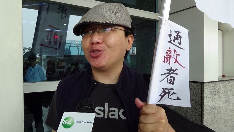 张先生手持“剿匪”旗进行一个人的陈抗遭呛。(记者夏小华摄)