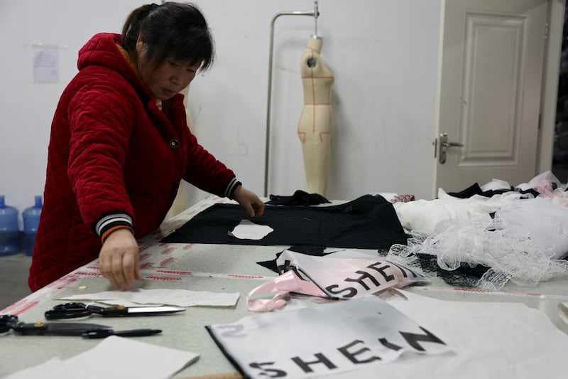 A worker prepares to cut a fabric next to Shein packaging in Guanyun county of Lianyungang, Jiangsu province, China, Nov. 25, 2024.