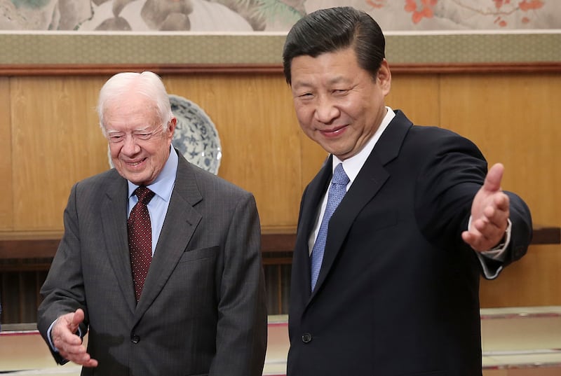 Chinese leader Xi Jinping, right, gestures to former U.S. President Jimmy Carter during a meeting in Beijing, Dec. 13, 2012.