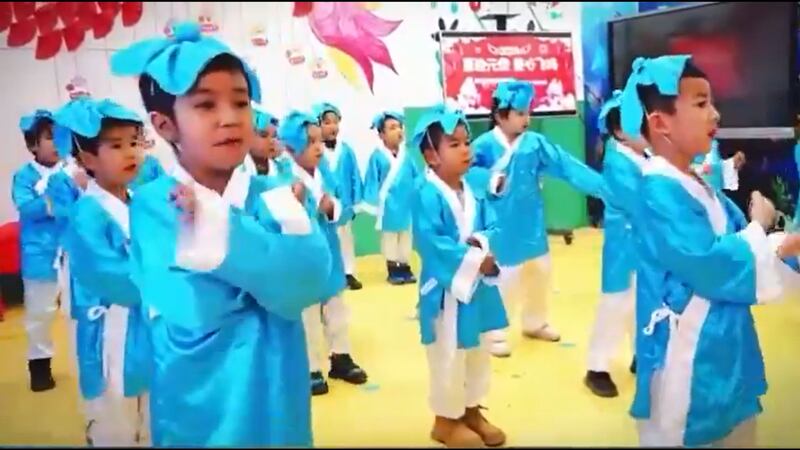 ئامېرىكادىكى سىياسىي كۆزەتچى ئىلشات ھەسەن ئەپەندى X تە ھەمبەھىرلىگەن، يېڭى يىل ھارپىسىدا «دوۋيىن» دا تارقىتىلغان ۋىدېيودا خوتەن ۋىلايىتى نىيە ناھىيىسى رۇكىيا يېزىسىنىڭ مەركەز يەسلىسىدىكى ئۇيغۇر بالىلىرىنىڭ خىتاينىڭ ئەنئەنىۋى كىيىم-كېچەكلىرىنى كىيگەن ھالەتتە خىتايچە ئۇسسۇل ئويناپ، دۇمباق چېلىۋاتقان كۆرۈنۈشى. 2023-يىلى 31-دېكابىر، نىيە ناھىيىسى.