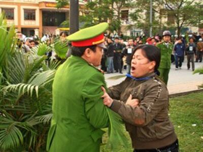 Công an ngăn cản một nữ giáo dân phía trước phiên tòa xử 8 giáo dân Thái Hà hôm 8-12-2008.