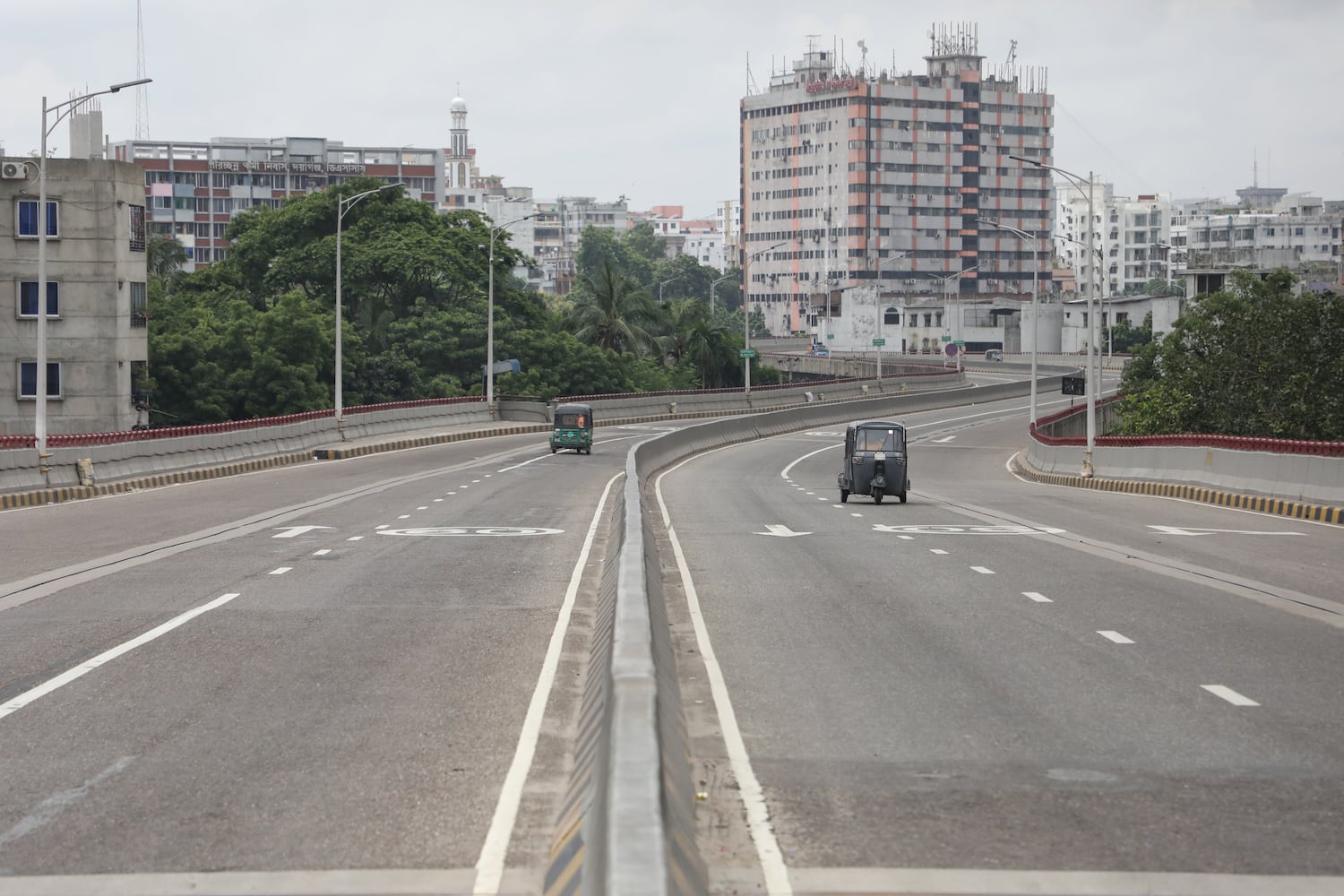 Two auto rickshaws are seen on an otherwise empty road during a nationwide curfew in the Jatrabari area in Bangladesh's capital, Dhaka, July 22, 2024. [Jibon Ahmed/BenarNews]