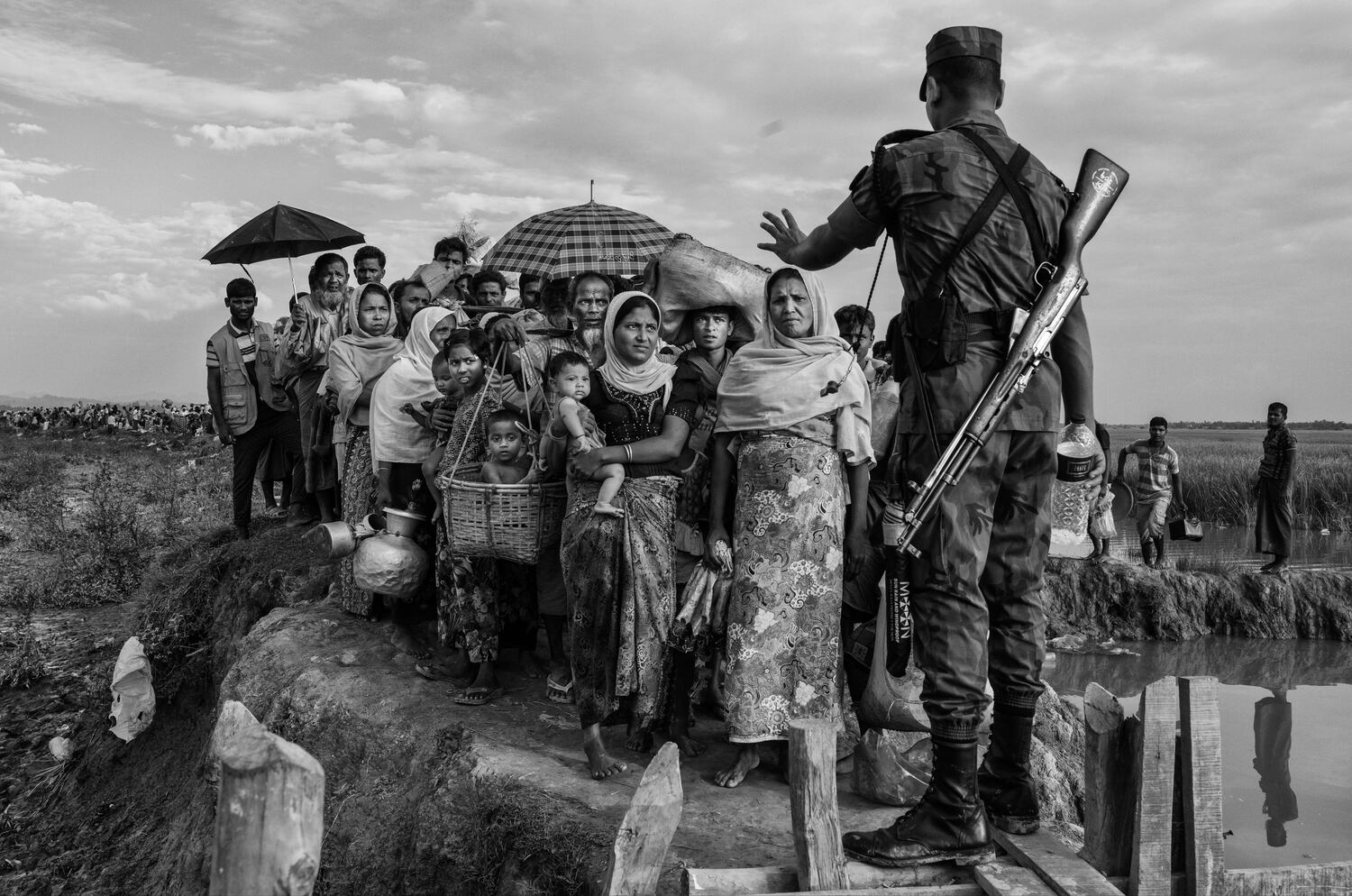 Un oficial de la guardia fronteriza de BGB Bangladesh hace gestos mientras controla a una multitud de refugiados musulmanes rohingya que esperan ingresar a los campamentos después de cruzar la frontera entre Myanmar y Bangladesh cerca del río Naf cerca de Anjuman Para en Cox's Bazar, Bangladesh, el 2 de noviembre de 2017. (Kevin Frayer/Getty Images)