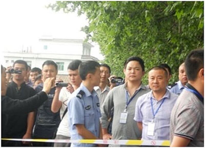 當局暴力徵地引起逾千群眾圍觀，警察在場拉起警戒線禁止群眾闖進。期間有公安便衣在場不斷拍攝圍觀群眾的舉動，以防有人鬧事。（村民余先生提供）