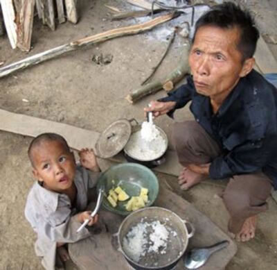 Bữa cơm của bố con ông A Páo ở trước hang đá Mông Ân. Source Laodong.com