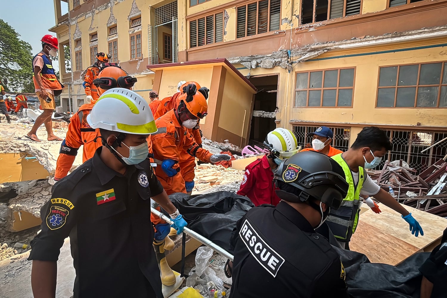 Indian and Myanmar rescuers carry a body at U Hla Thein Buddhist monastery that collapsed in Friday's earthquake in Mandalay, Myanmar, March 31, 2025.